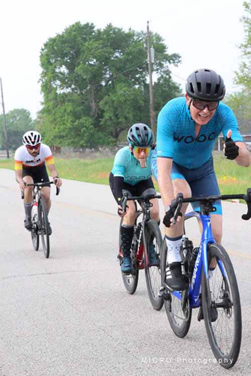 Cycling race during daytime on paved road with riders wearing helmets and colorful jerseys.