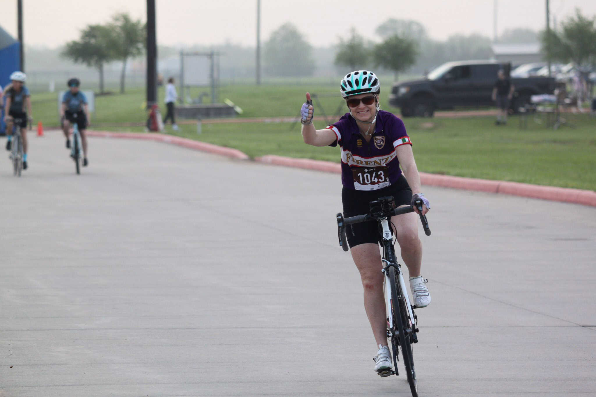 Bike race participant smiling and giving a thumbs-up during Bluebonnet Express event.