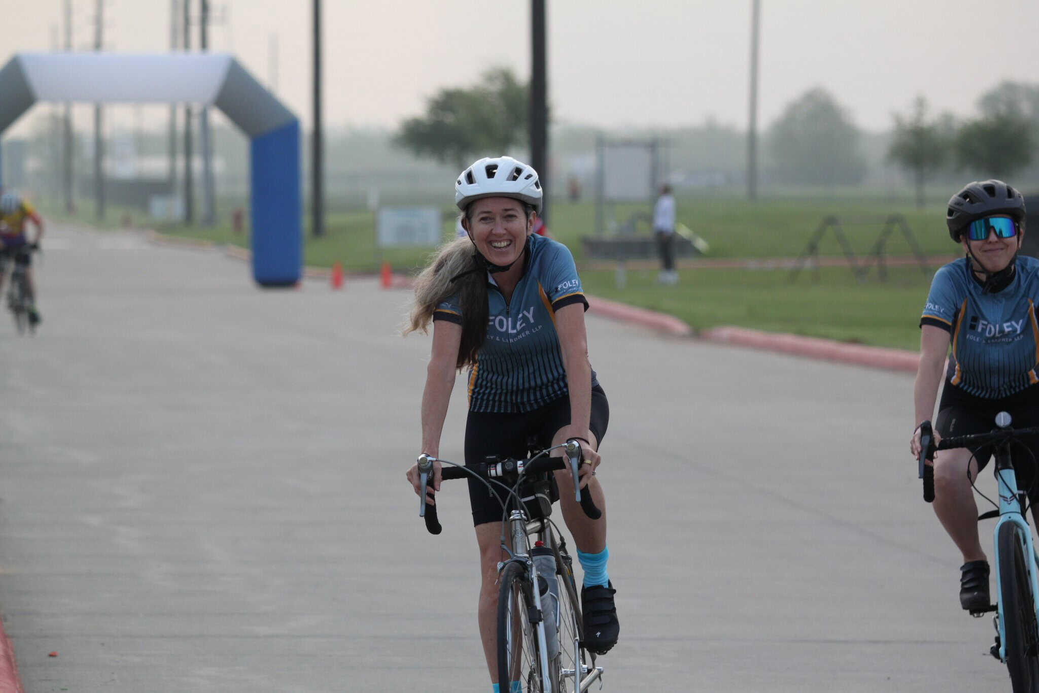 Smiling female cyclist riding on Bluebonnet Express bike route during cycling event.