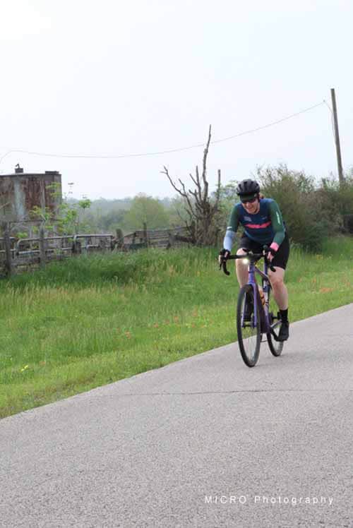 Bike rider on scenic rural trail during daytime.