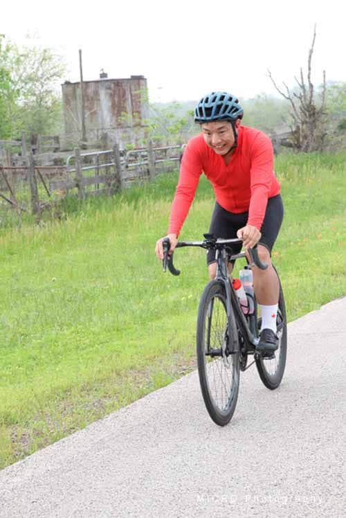 Bright woman cycling outdoors on a sunny day, promoting Bluebonnet Express bike service, eco-friendly transportation option.