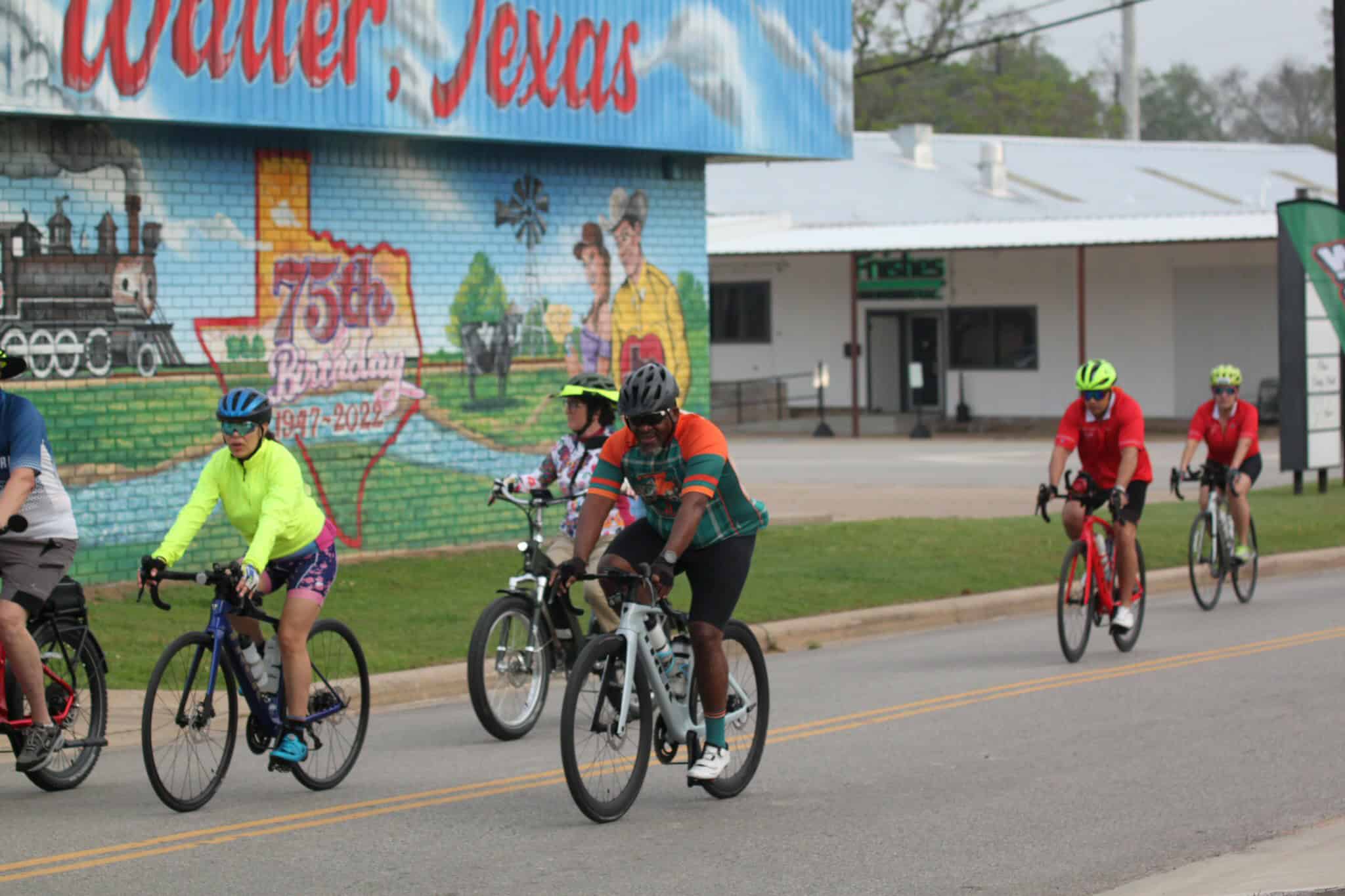 Brightly dressed cyclists enjoying a group ride on a sunny day in Texas.