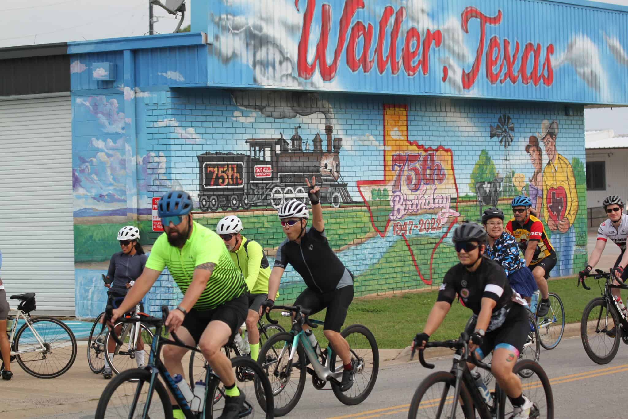 Colorful mural commemorating 75th anniversary of Waller, Texas, featuring historic train and community scene.