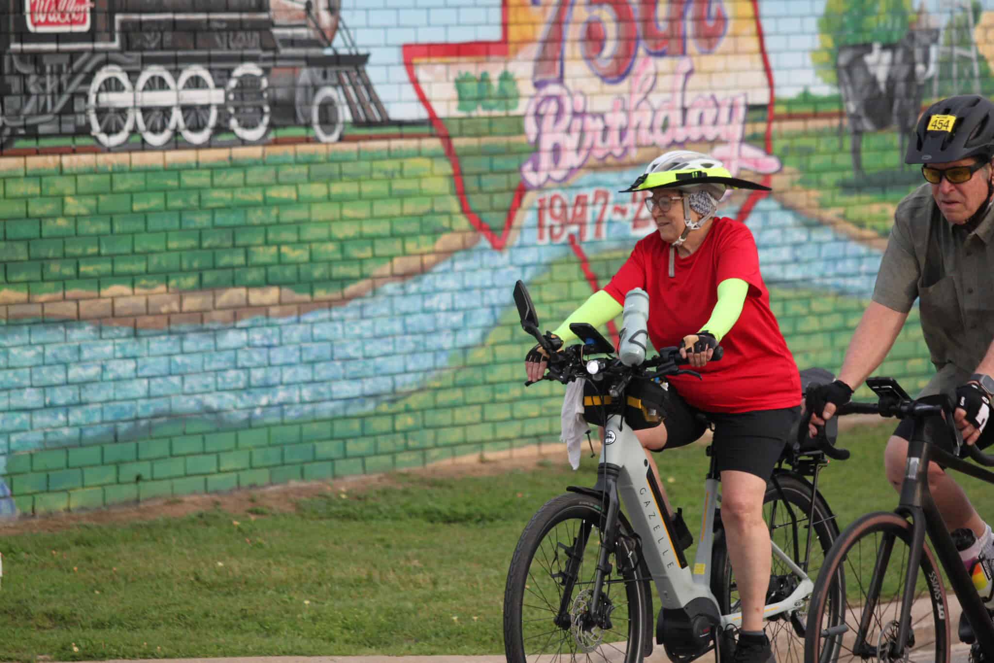 Electric bike riders enjoying a scenic ride along a colorful mural in Bexar County, Texas.