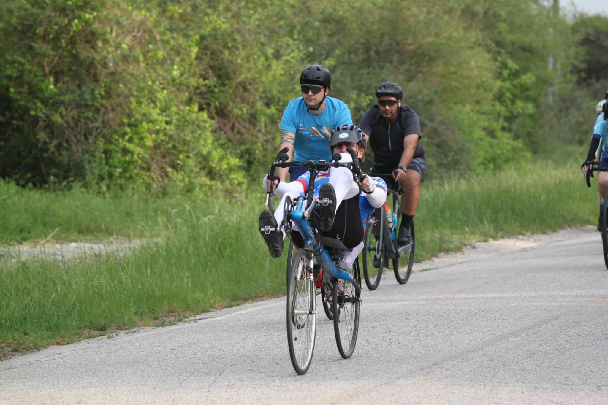 Riders on bicycles during Bluebonnet Express cycling event in scenic outdoor setting.