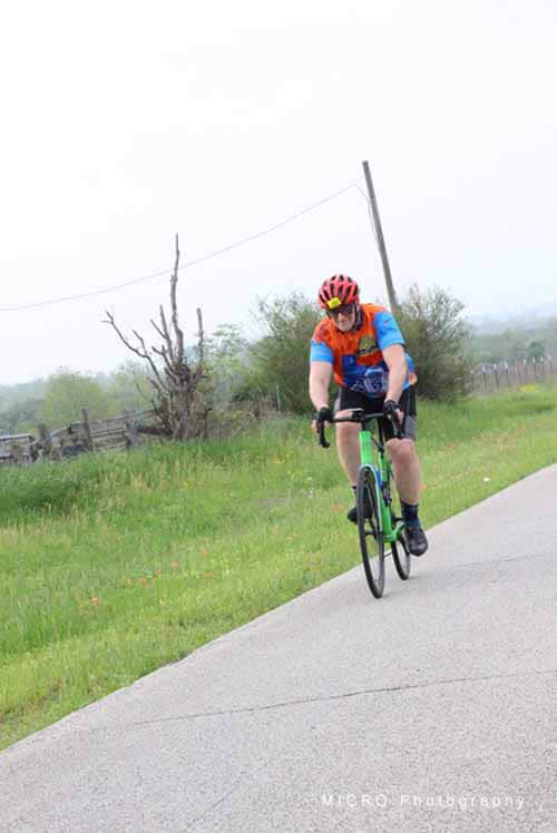 Bright cyclist riding on a scenic rural trail during daytime in Bluebonnet Express event.