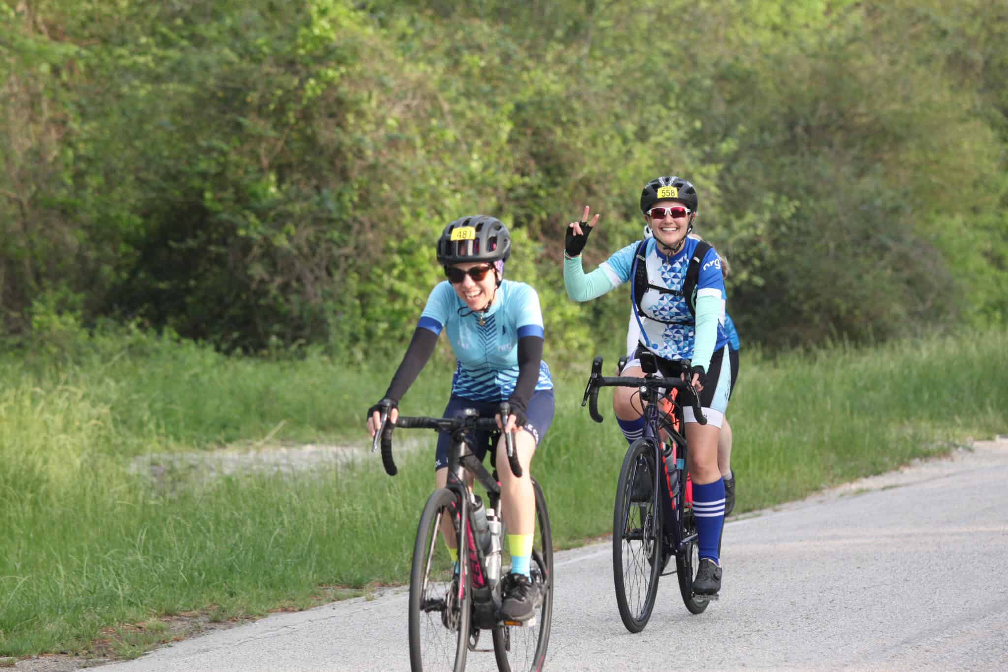 Brightly colored cyclists enjoying a scenic ride on a bike trail surrounded by greenery.