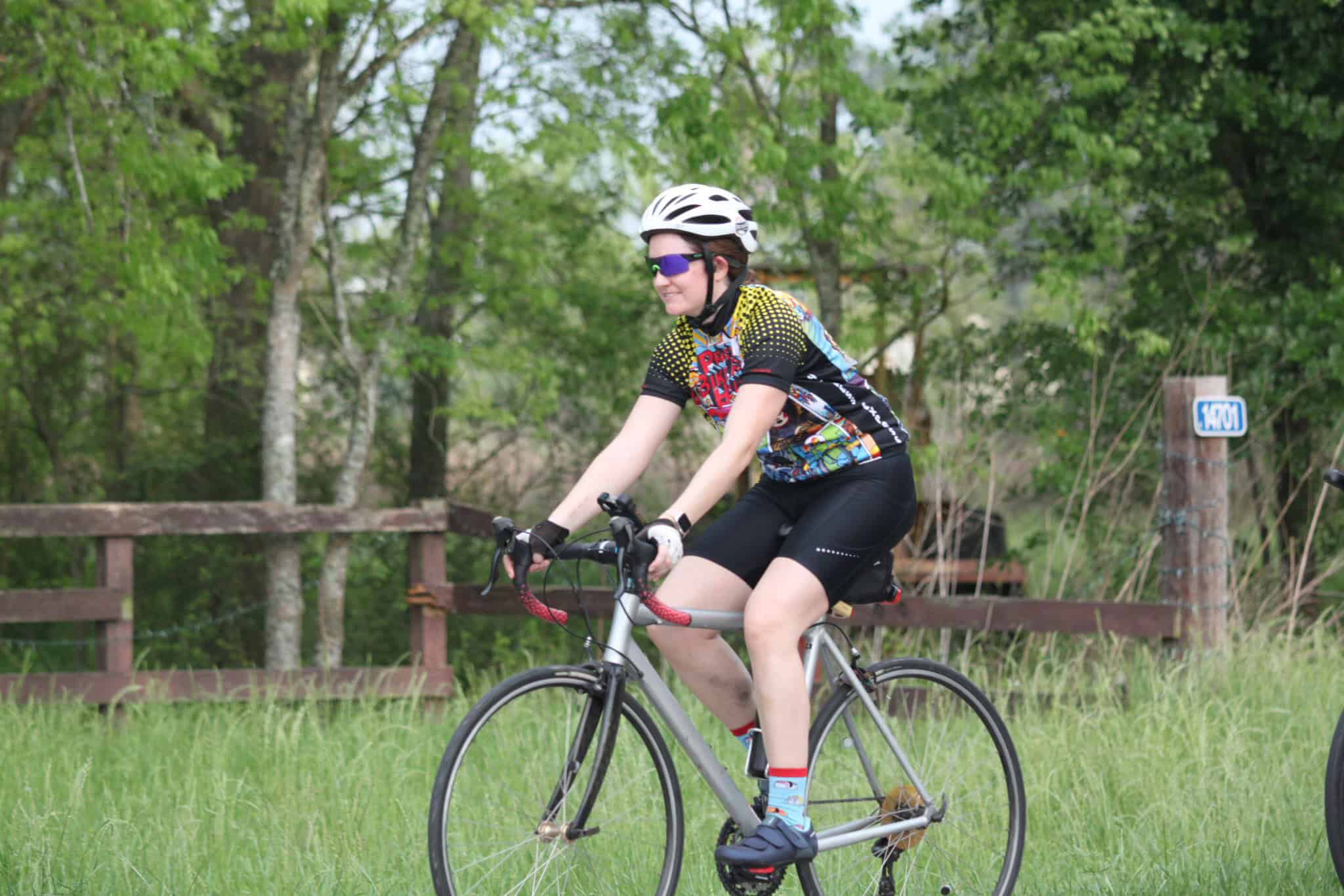Vibrant cyclist enjoying a scenic ride along Bluebonnet Express trail surrounded by lush greenery.