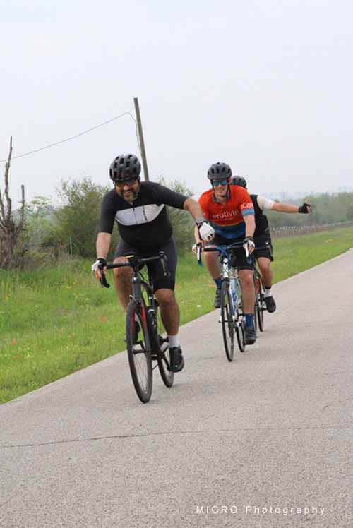 Brightly colored cyclists riding on a scenic outdoor road in the 2025 Bluebonnet Express event.