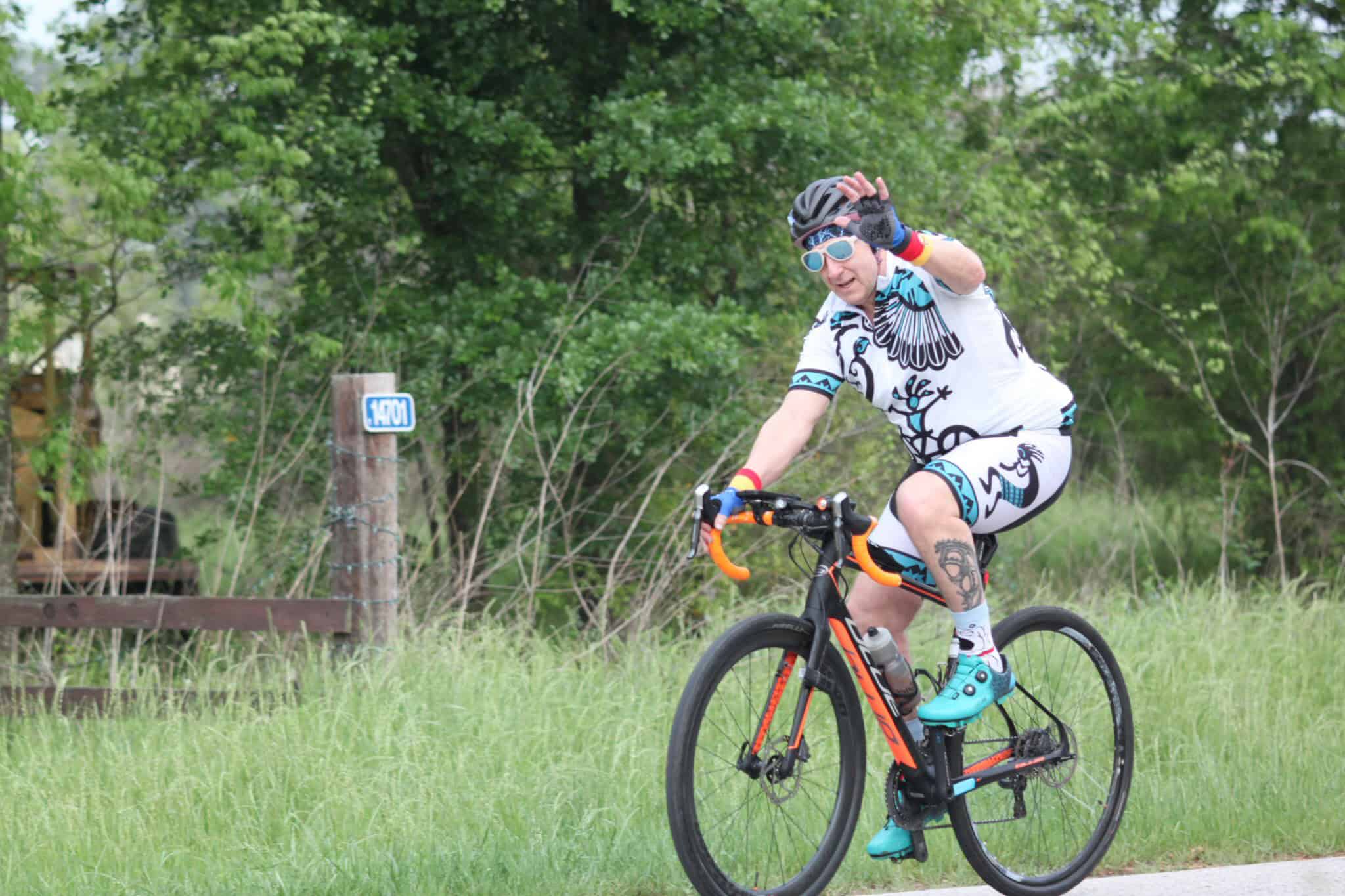 Vibrant cyclist riding a mountain bike in nature, highlights Bluebonnet Express cycling event.