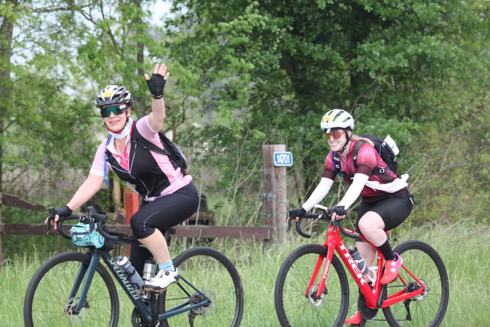 Vibrant cyclists enjoying scenic ride on Bluebonnet Express trail amidst lush greenery.