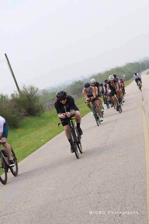 Cyclists riding in a group on a scenic rural road during Bluebonnet Express event.