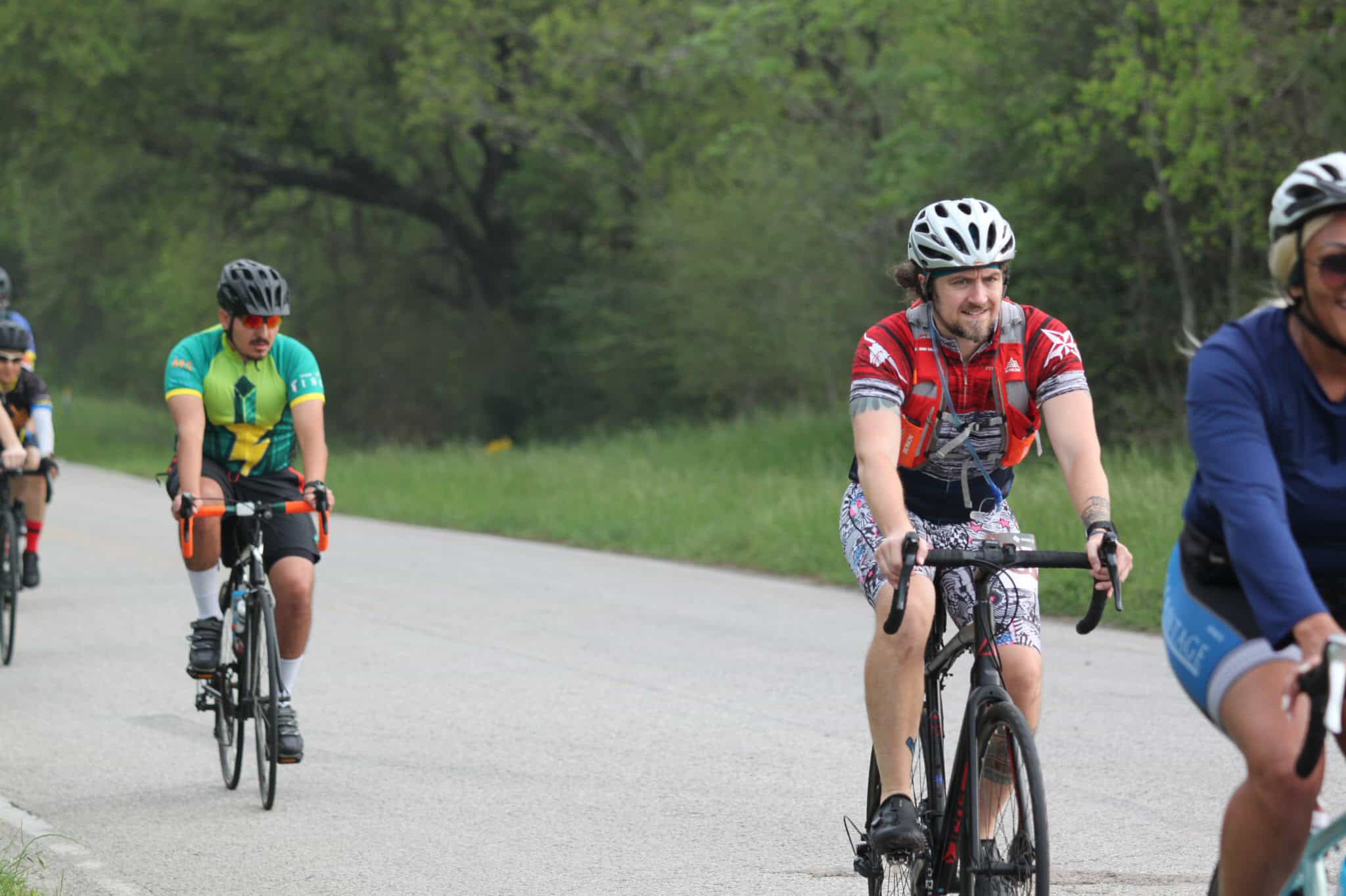 Bicycle riders participating in Bluebonnet Express cycling event on scenic outdoor trail.
