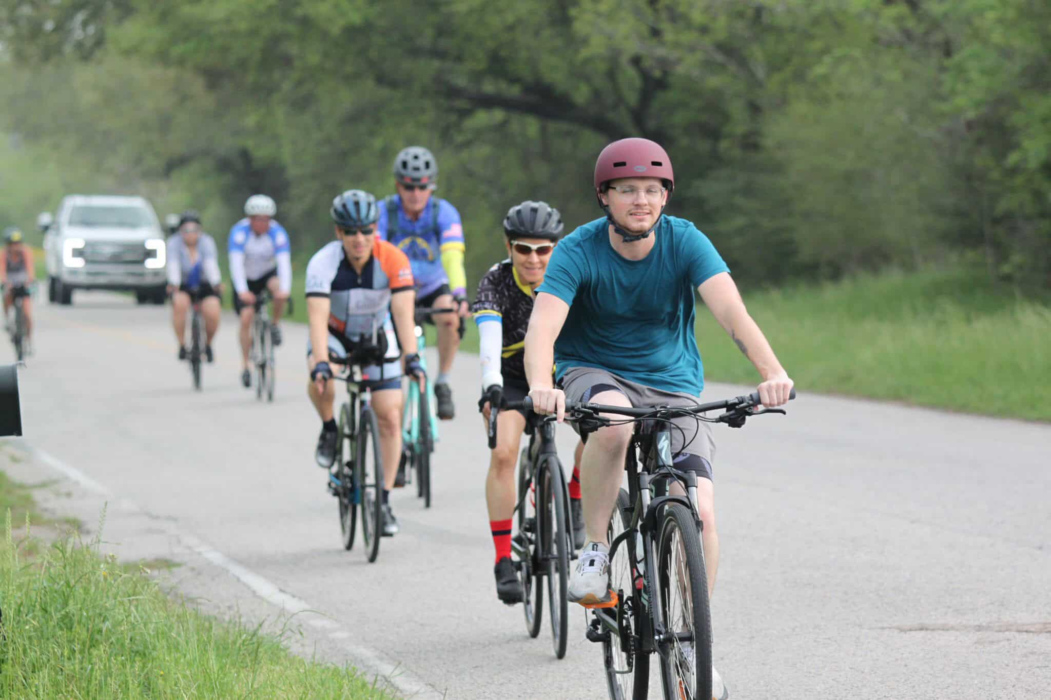 Active cycling group on scenic road for Bluebonnet Express event.