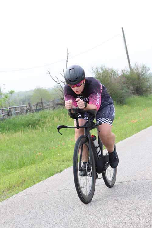 Boy riding a racing bicycle on a rural road during daytime.