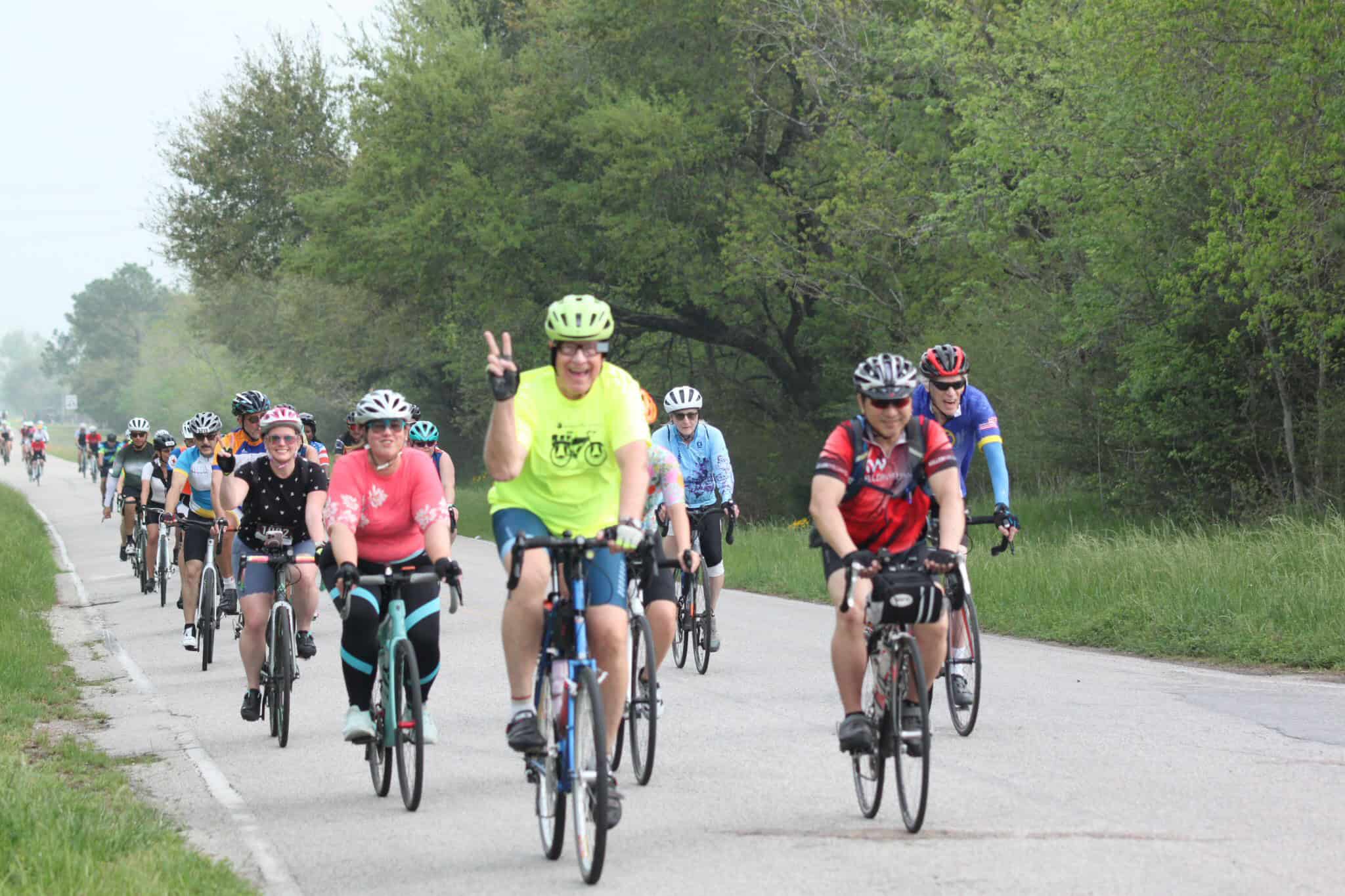 Vibrant group cycling event on a scenic green trail, promoting outdoor fun and active transportation.