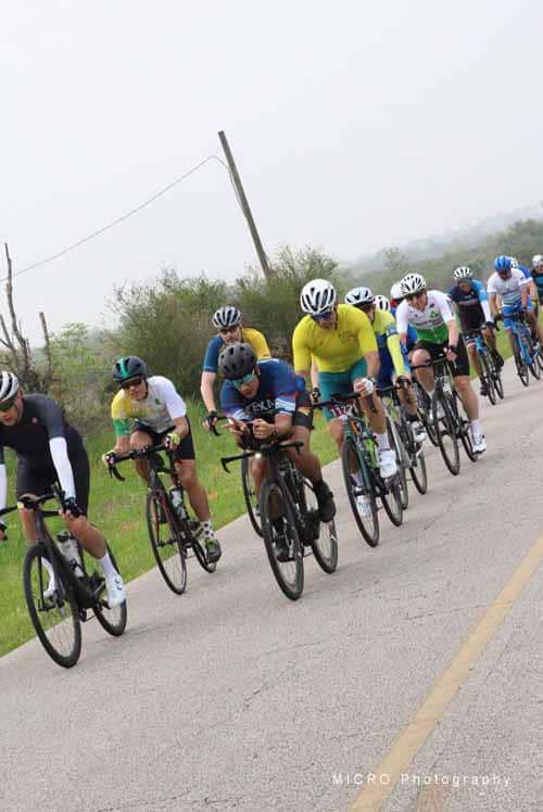 Cyclists racing on a scenic road during Bluebonnet Express event in Texas.