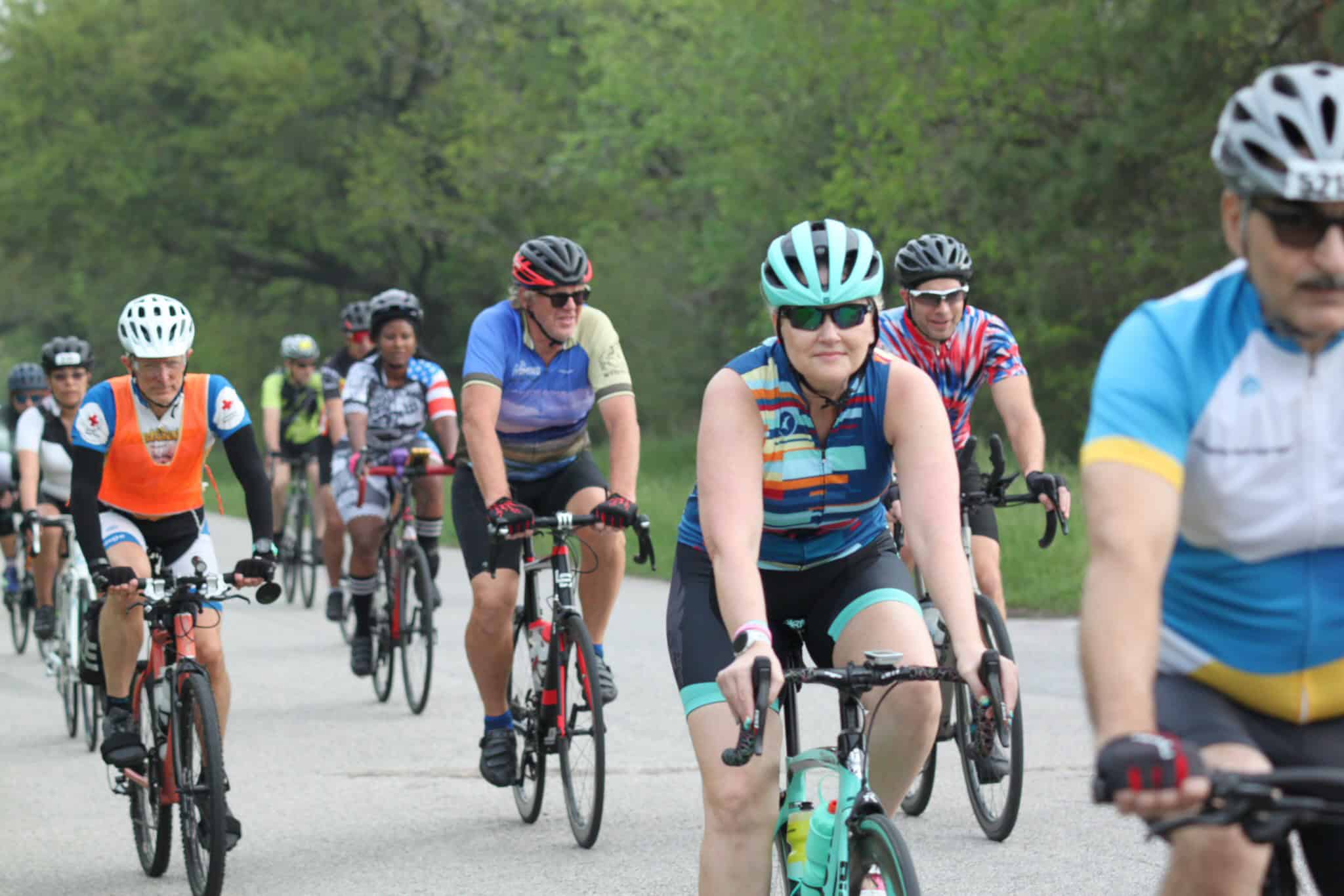 Vibrant group of cyclists enjoying a scenic ride on the Bluebonnet Express trail in spring.