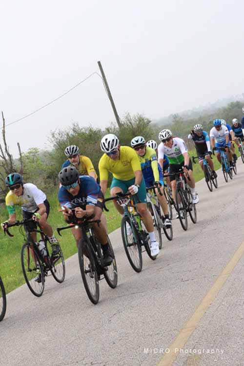 Cyclists riding on a scenic road during Bluebonnet Express bike event.