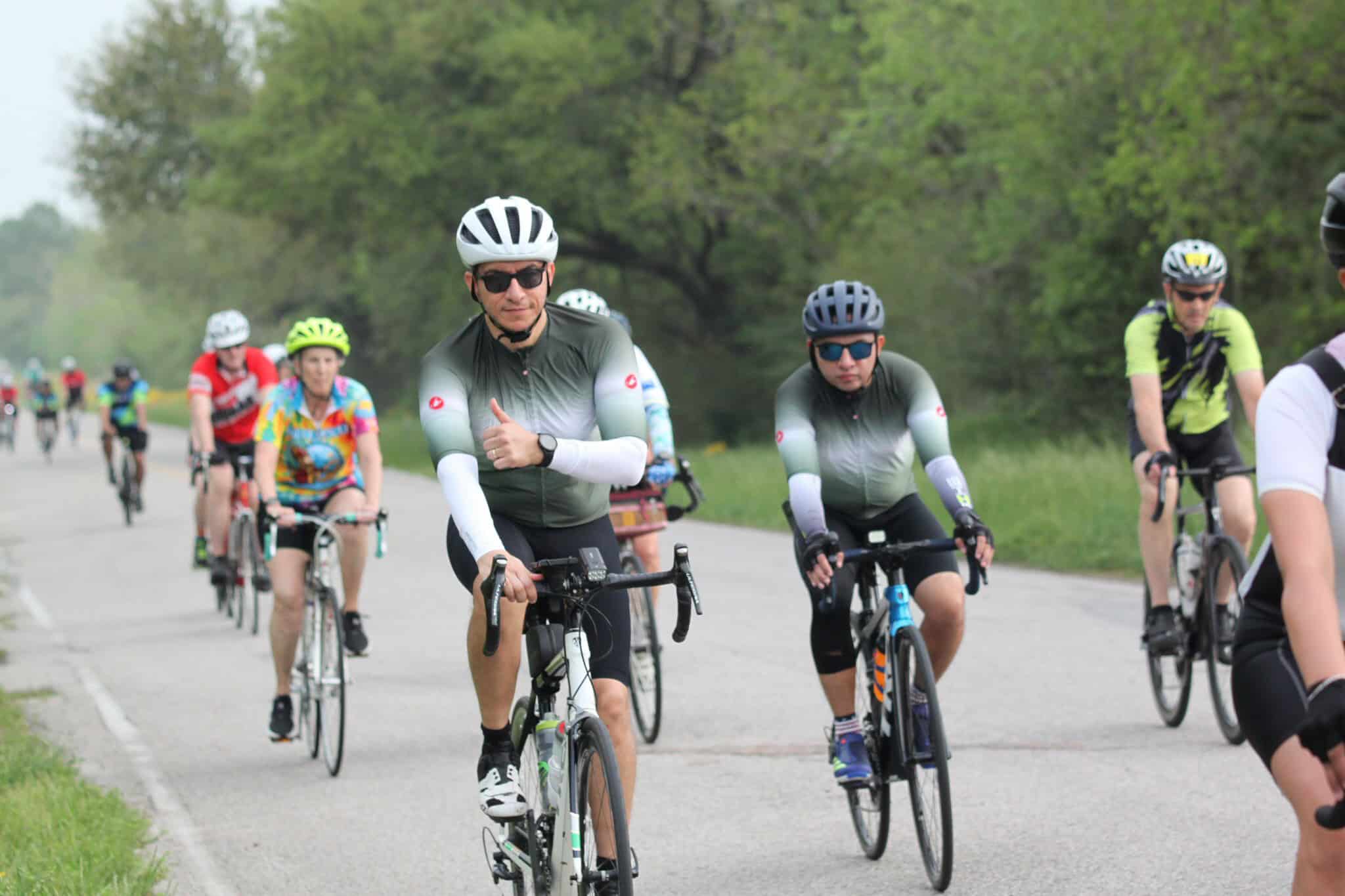 Cyclists enjoying a scenic ride along Bluebonnet Express route in lush green surroundings.