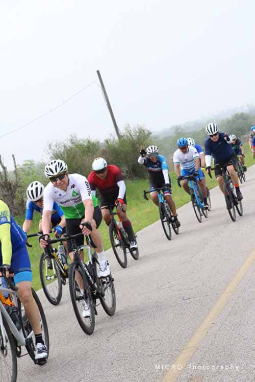 Cyclists riding on a scenic road during Bluebonnet Express event, promoting active outdoor recreation.