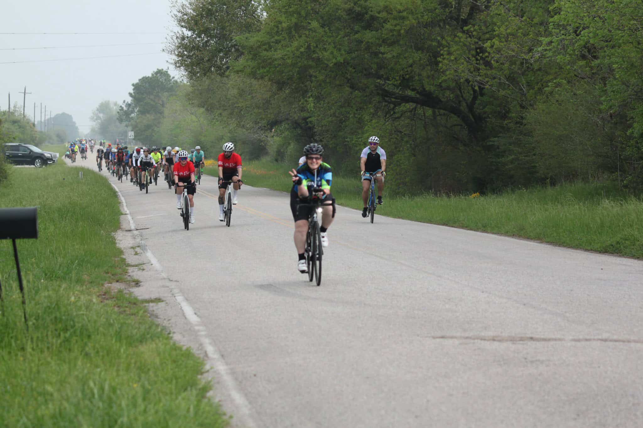 Bicycle riders participating in the Bluebonnet Express event along a scenic rural road.
