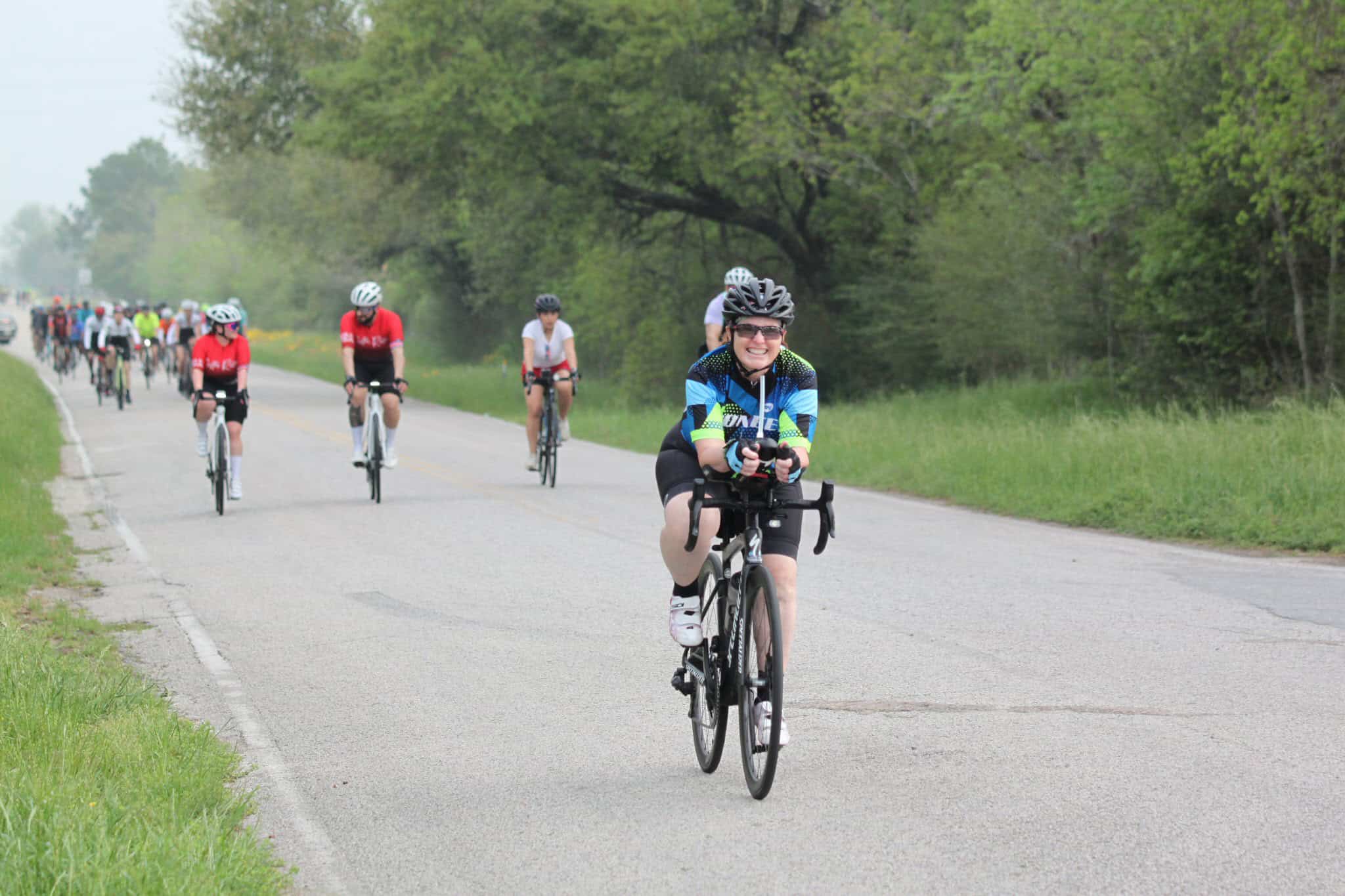 Youth cycling event on scenic rural road, part of Bluebonnet Express bike ride.