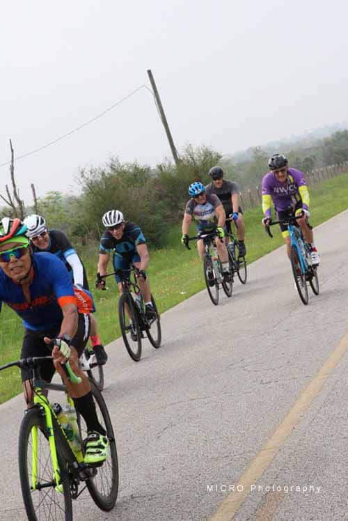 Vibrant group of cyclists riding on a countryside road, enjoying outdoor biking adventure.