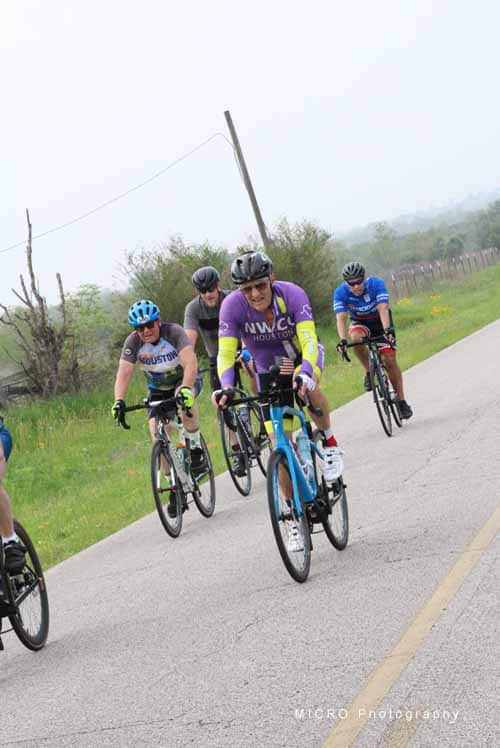 Riders participating in the Bluebonnet Express cycling event on a scenic rural road.