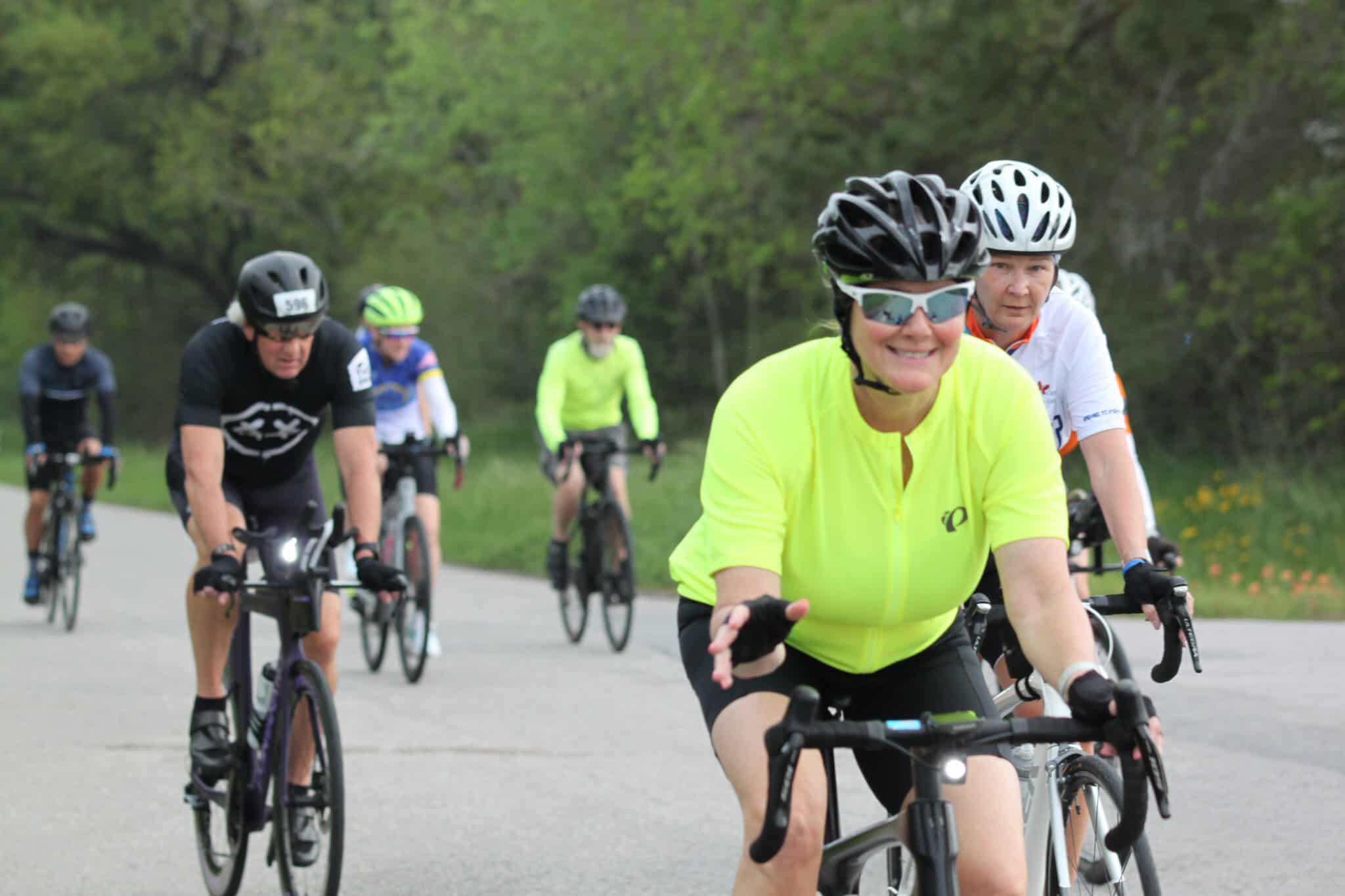 Bright yellow cycling jersey worn by female cyclist during Bluebonnet Express event, leading others on a scenic ride.