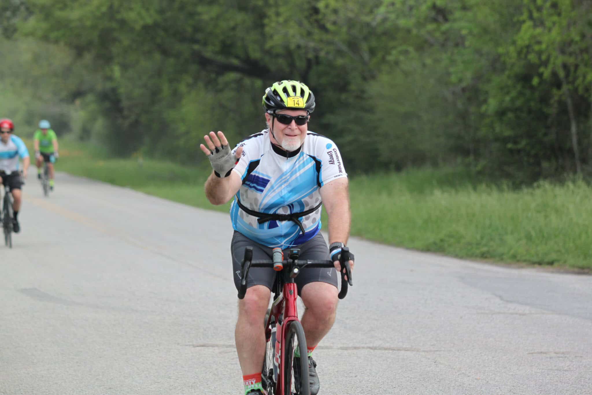 Pedestrian cyclist riding along scenic rural road in Bluebonnet Express event.