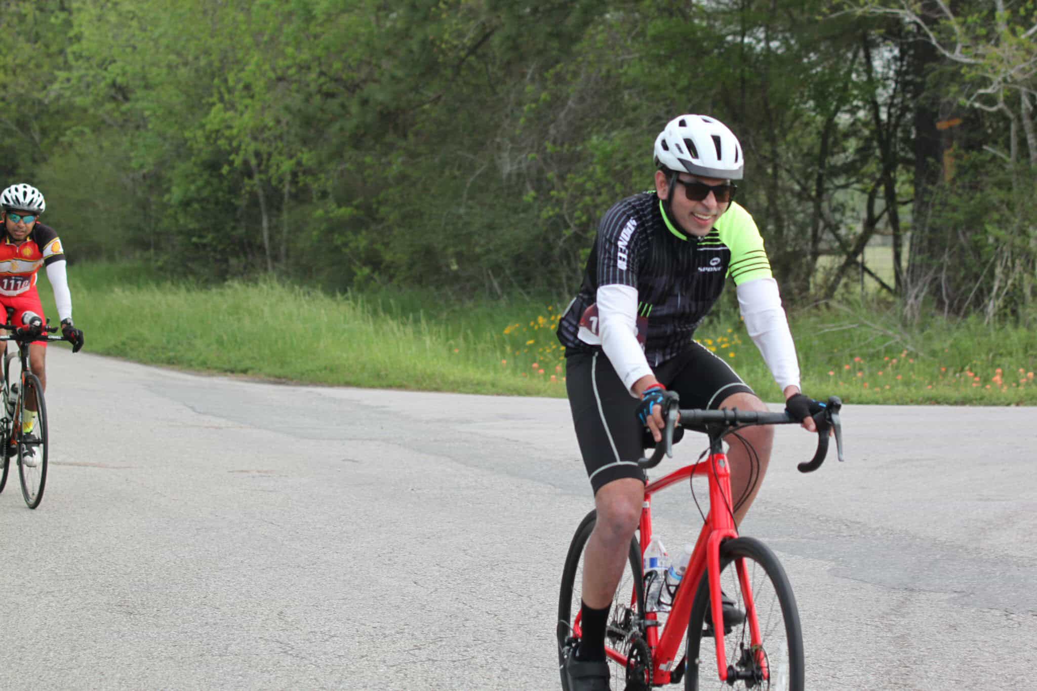 Vibrant cyclist riding a road bike during Bluebonnet Express race in scenic outdoor setting.
