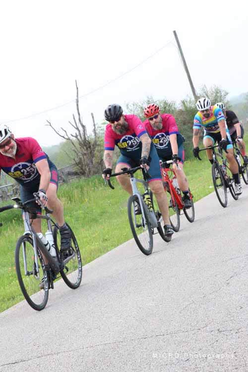 Bright cyclists riding on a rural road during Bluebonnet Express cycling event.
