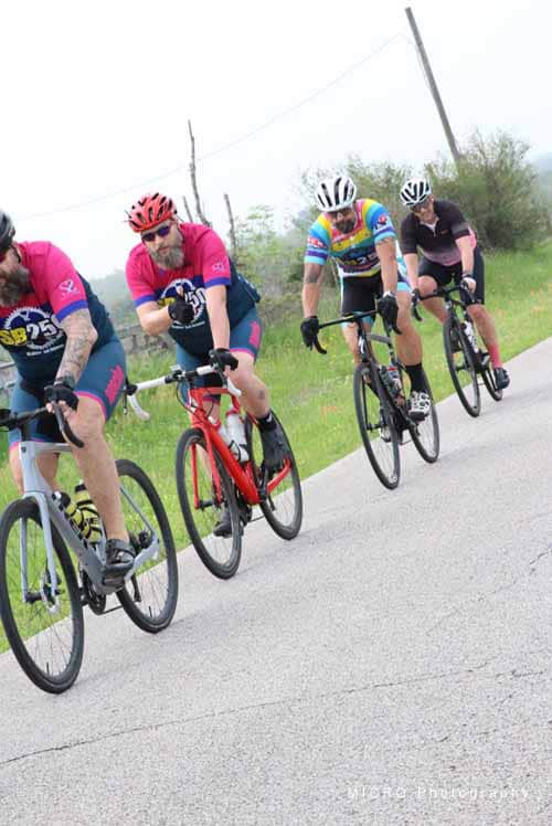Cyclists riding on a rural road during the Bluebonnet Express event, showcasing group biking and outdoor adventure.