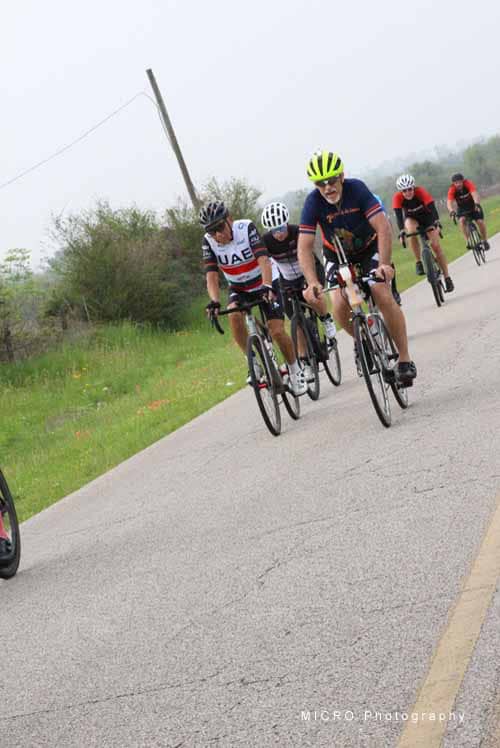 Cyclists riding on a scenic rural road during the Bluebonnet Express event in Texas.