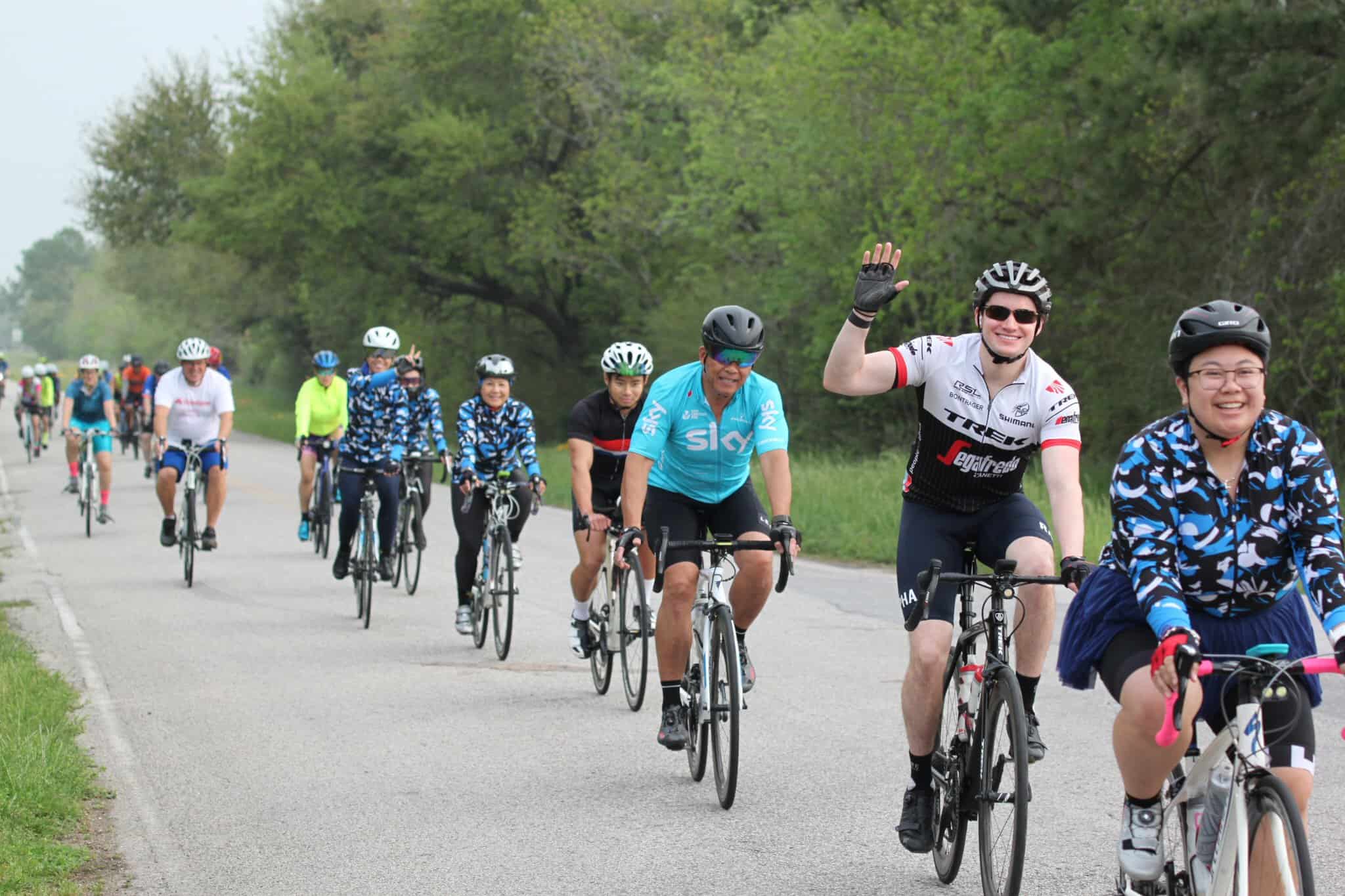 Colorful group ride on a scenic bike path highlighting Bluebonnet Express cycling event.