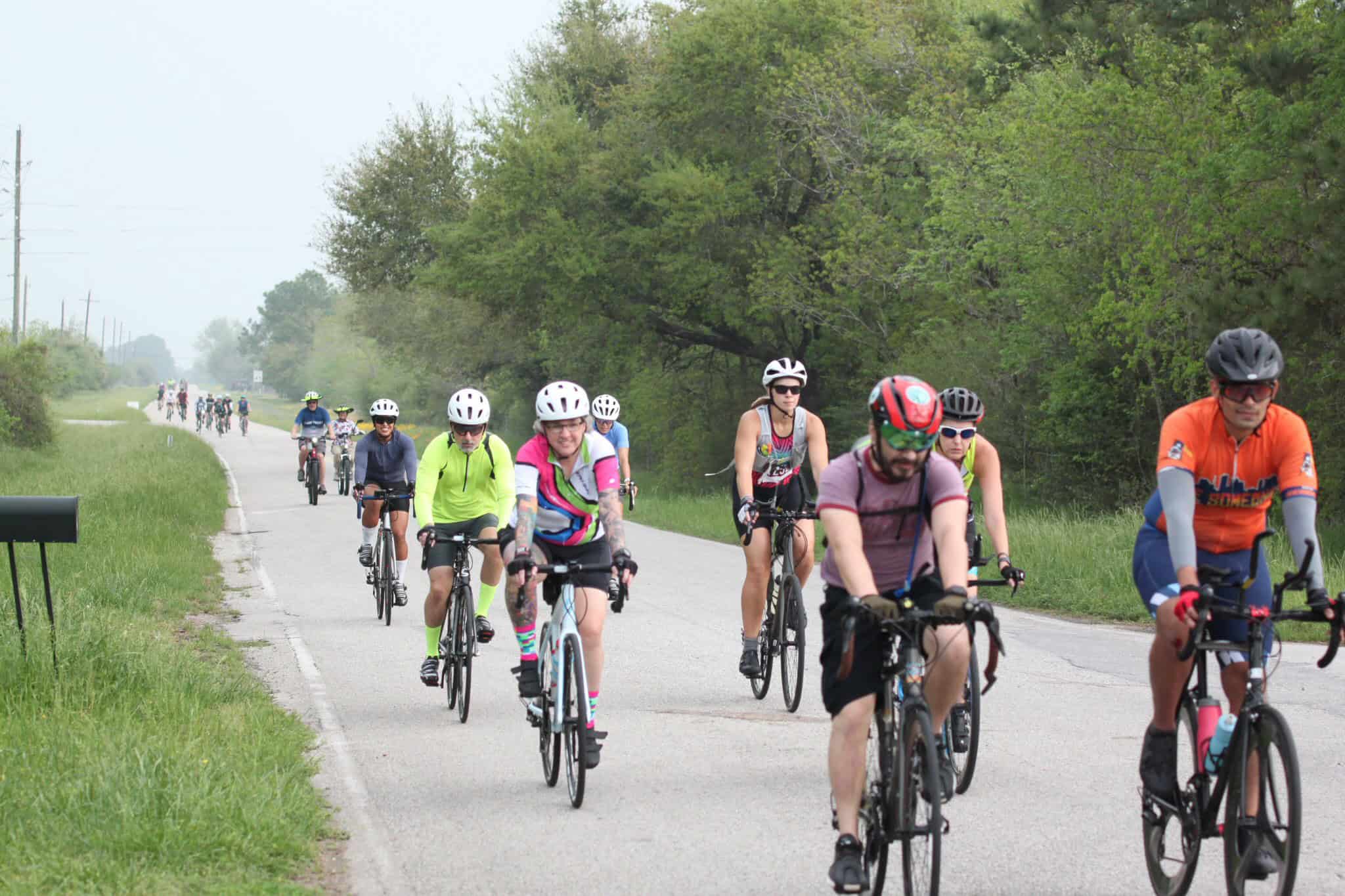 Beautiful group of cyclists riding on a scenic countryside bike trail during daytime.
