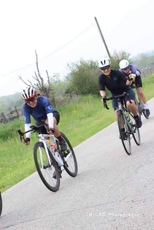 Velo riders on scenic rural bike trail during daytime, Bluebonnet Express cycling event.