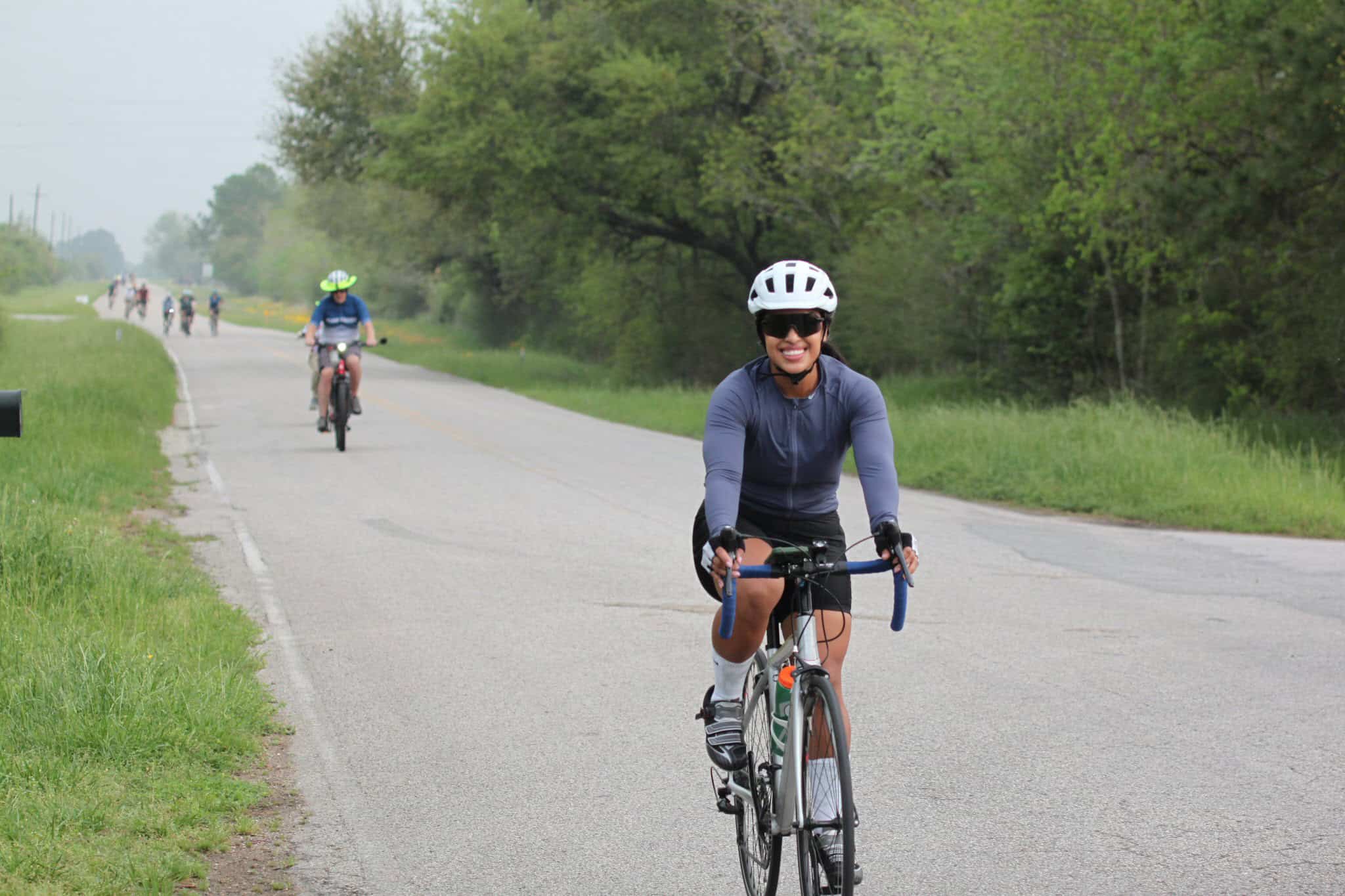 Bright female cyclist enjoying a scenic bike ride on Bluebonnet Express bike trail.
