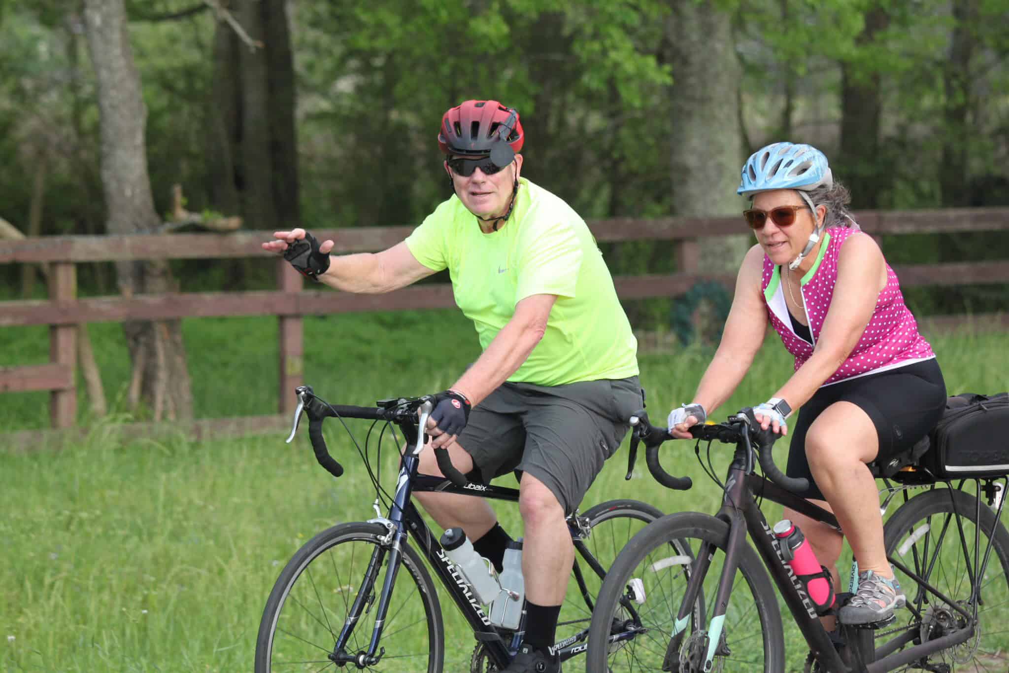 Vibrant cyclists enjoying a scenic ride through green countryside on Bluebonnet Express bike trail.