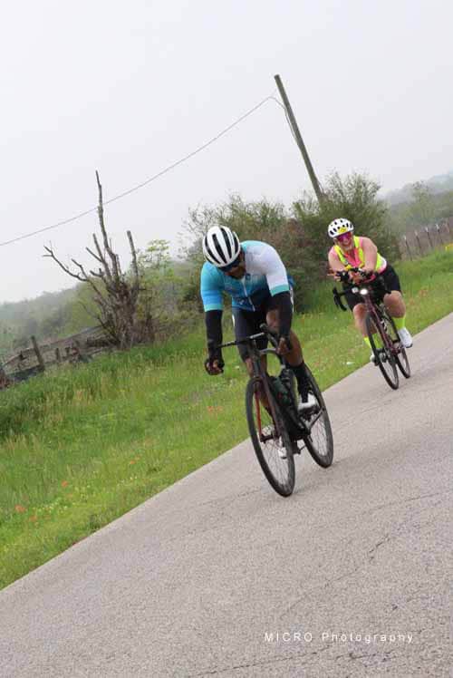 Cyclists riding along a scenic rural road during a bike tour, showcasing outdoor adventure and cycling fitness.
