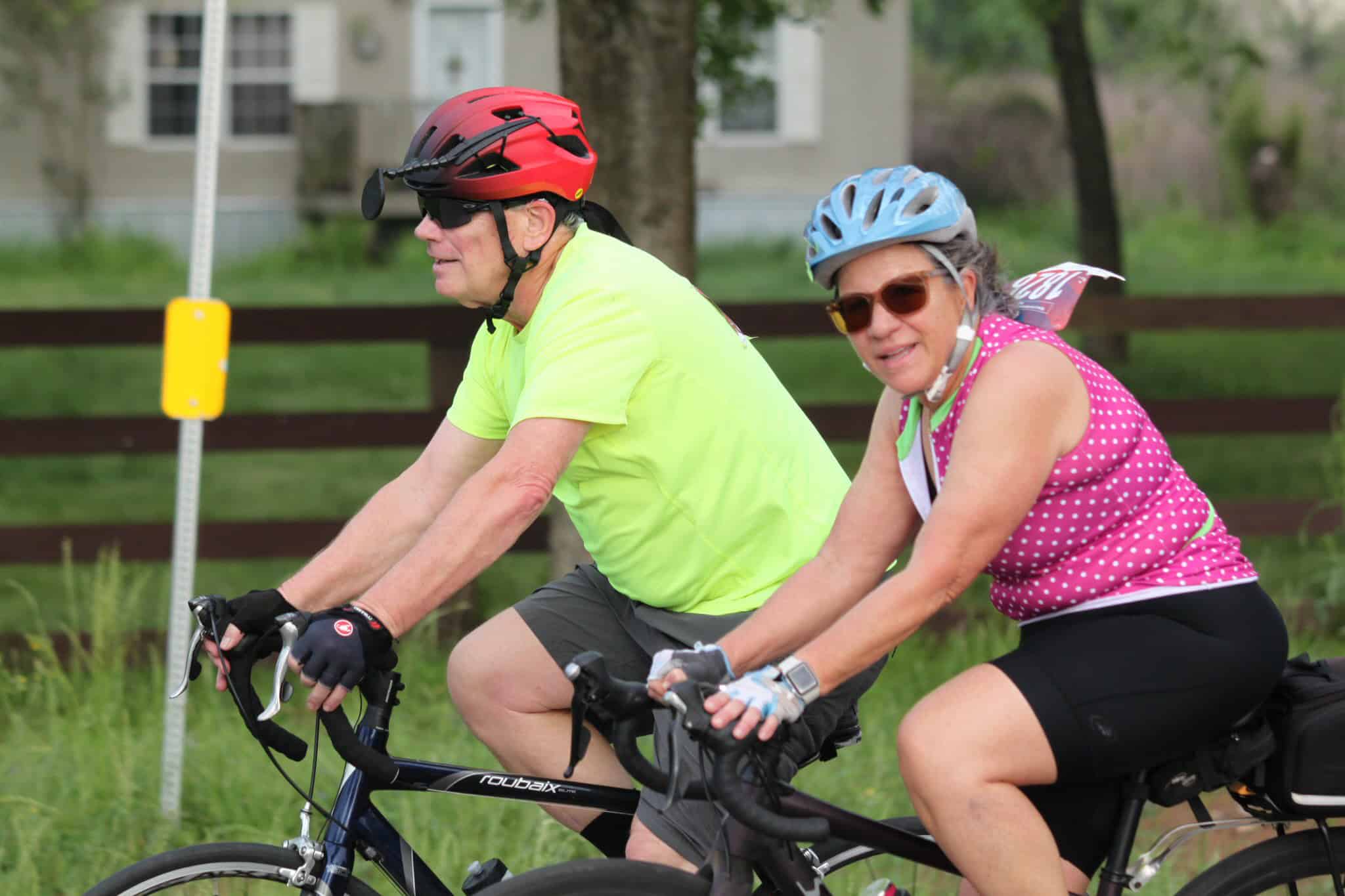 Cycling along Bluebonnet Express route with senior couple enjoying outdoor bike ride and wearing safety helmets.