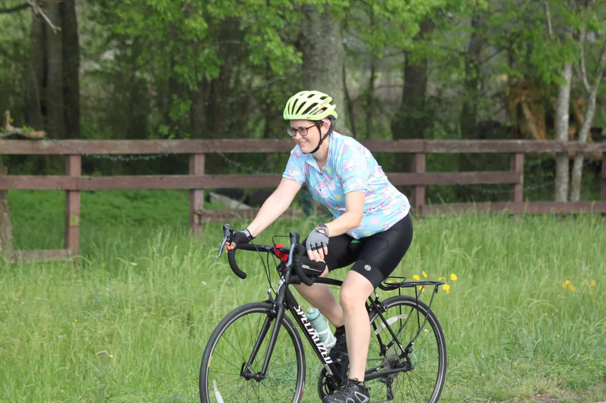 Bright yellow helmet on woman cycling through scenic green park for Bluebonnet Express.
