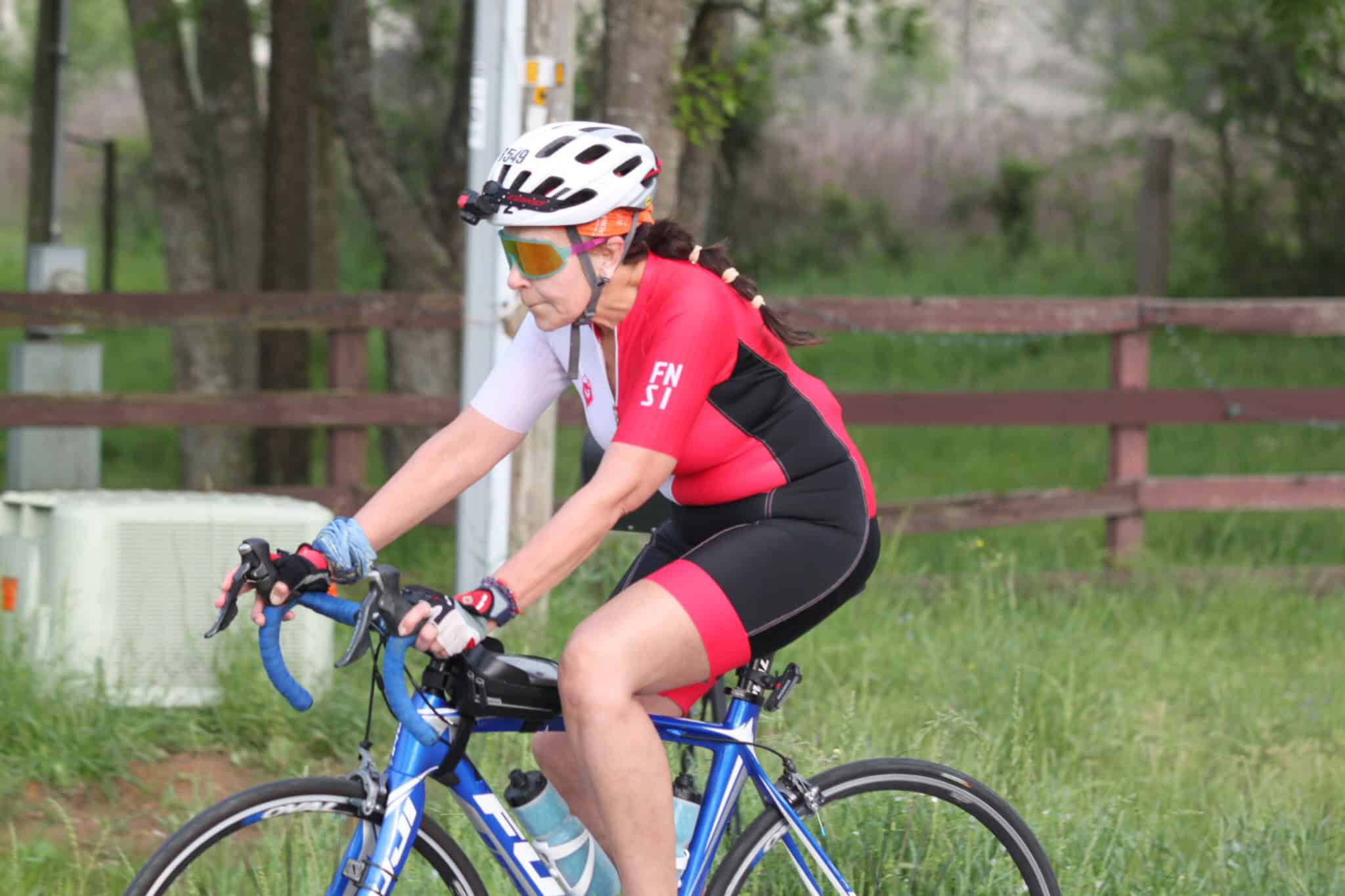Cyclist riding a Bluebonnet Express bike in a scenic outdoor trail.