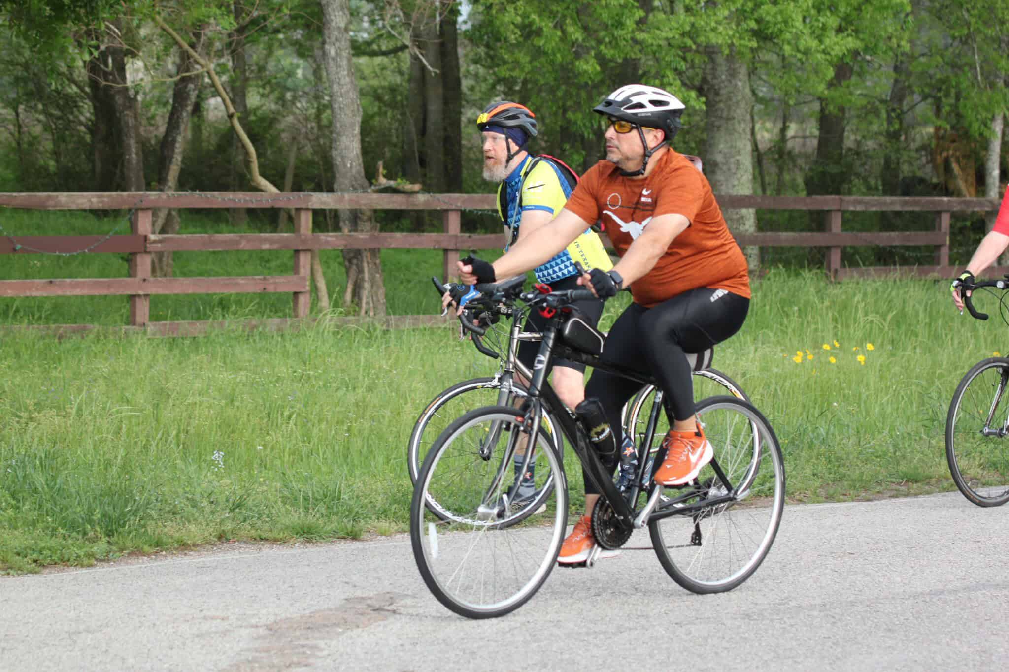 Bicycle riders enjoying a scenic ride along the Bluebonnet Express route through lush greenery.