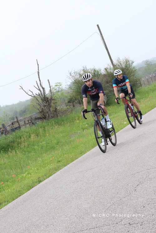Bright outdoor cycling scene with two riders on Bluebonnet Express bike trail, showcasing scenic Texas cycling routes.