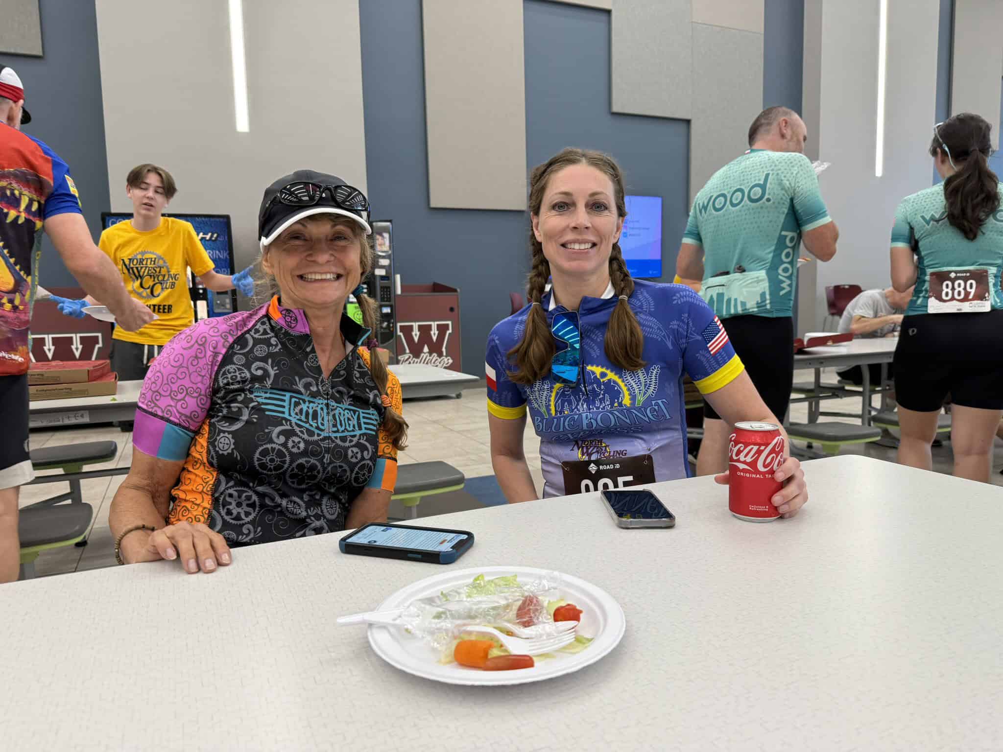 Smiling female cyclists after the Bluebonnet Express cycling event, enjoying refreshments at the race finish.