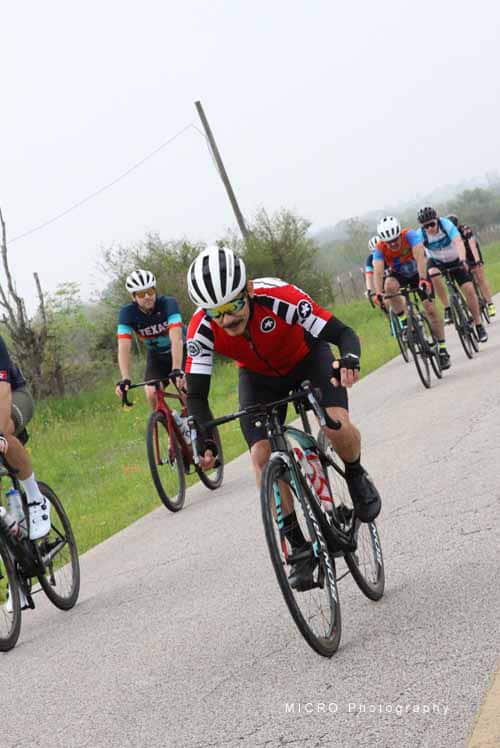 Cyclists riding during Bluebonnet Express event in Texas on a scenic rural road.