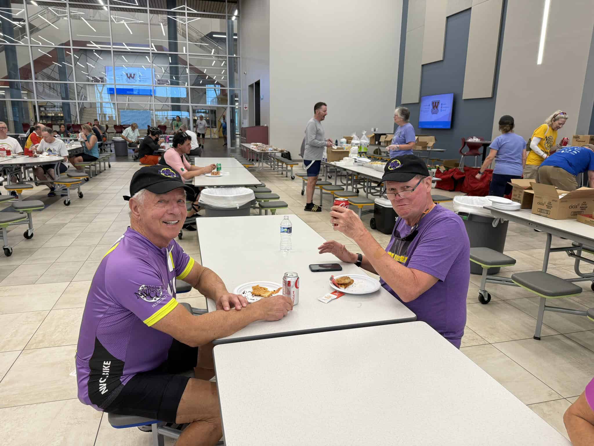 Enjoying a meal at Bluebonnet Express in a spacious, modern dining hall with cyclists in team gear.