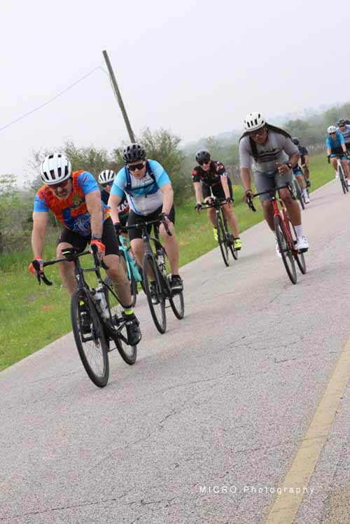 Veyo biking group riding on rural road, Bluebonnet Express event, Texas cycling race, outdoor recreational activity, cycling tour.
